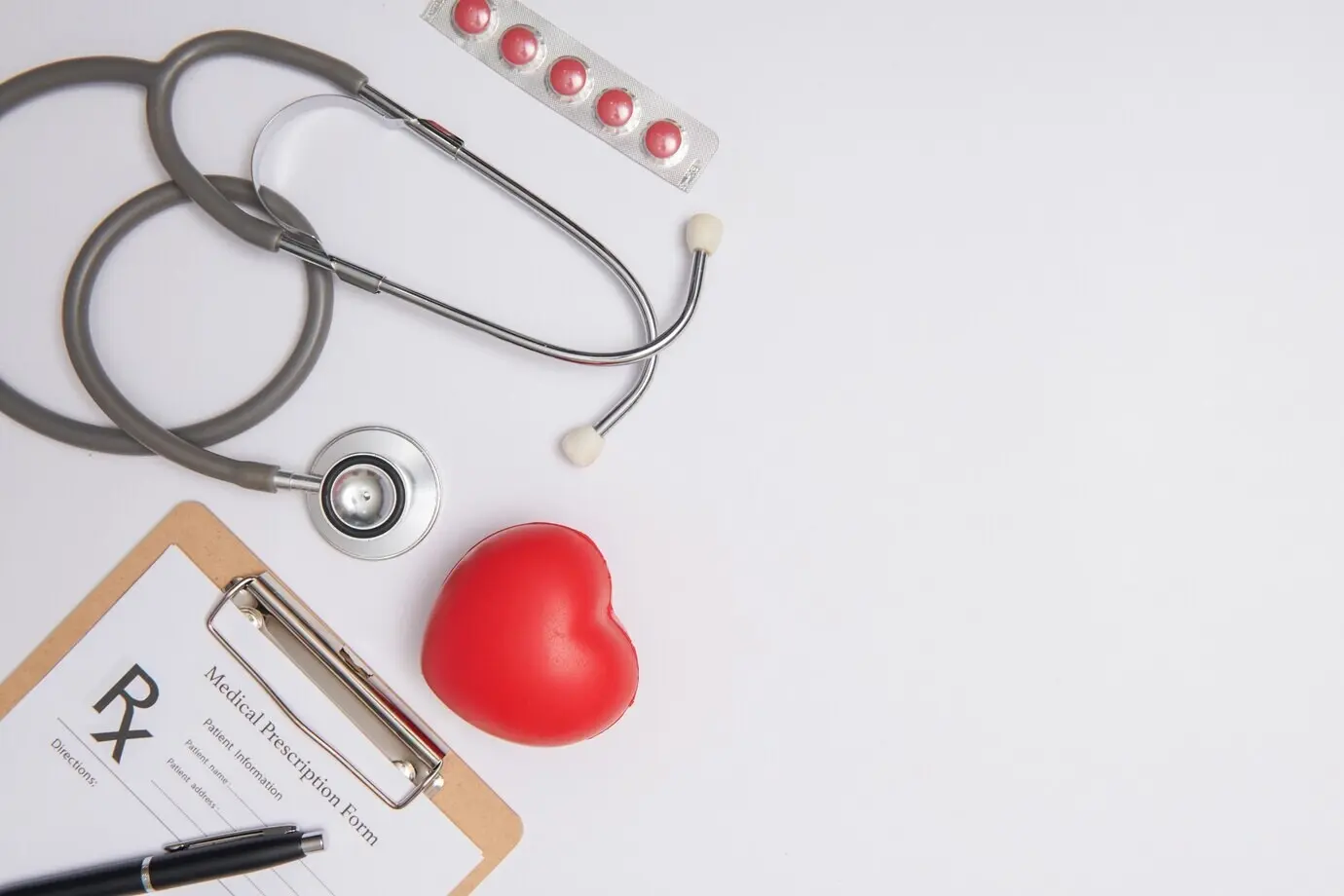 Estetoscopio con un corazón. Estetoscopio y corazón rojo sobre una mesa de madera. Concepto de seguro de vida hospitalario. Idea para el Día Mundial de la Salud del Corazón. Concepto de medicina o farmacia. Formulario médico en blanco listo para usar.